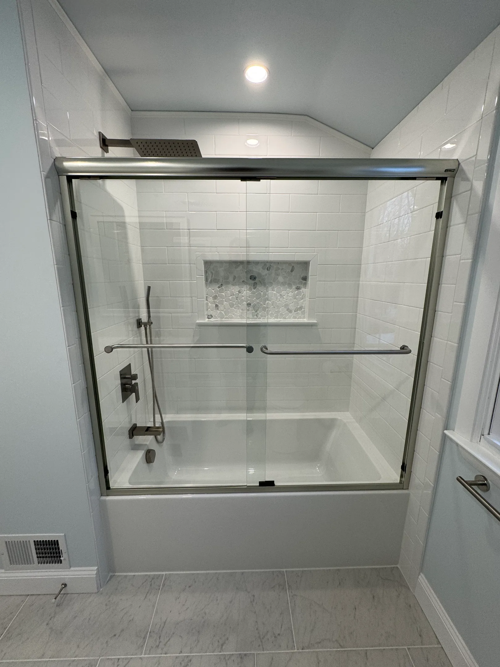 Frameless glass shower with white subway tile