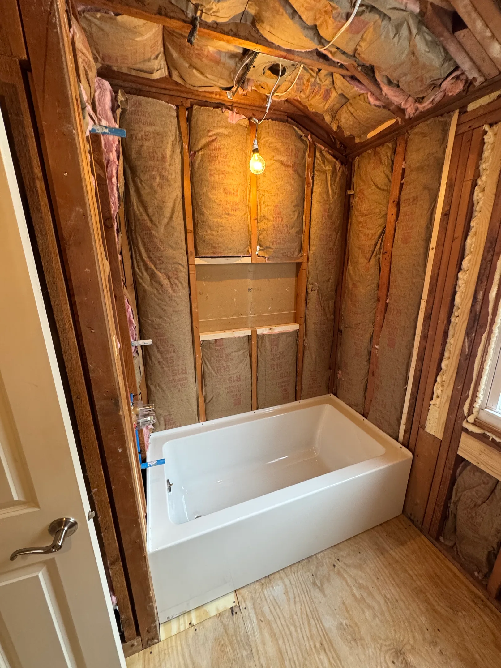 Custom built-in bathtub with wooden frame and white soaking tub