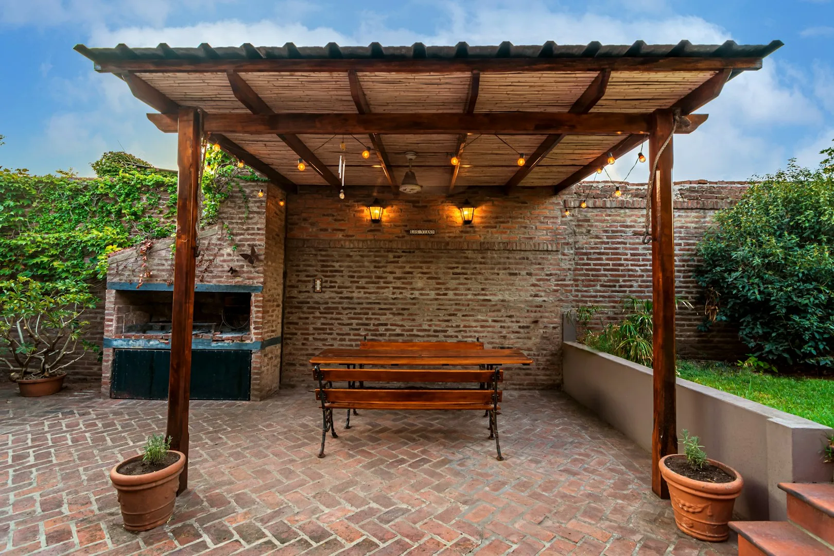 Covered outdoor patio with brick barbecue and pergola showcasing residential masonry work