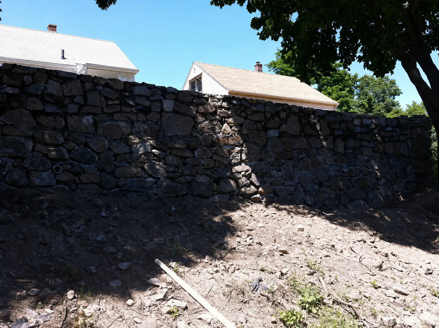 Rebuilt natural stone retaining wall replacing a collapsed wall at a Connecticut home