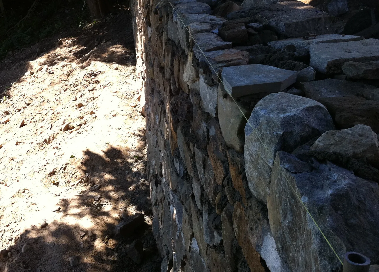 Natural stone set by hand to a string line during retaining wall construction